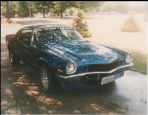 Front left view of a 1970 Camaro. It is blue with an L-88 style hood and front spoiler with custom wheels